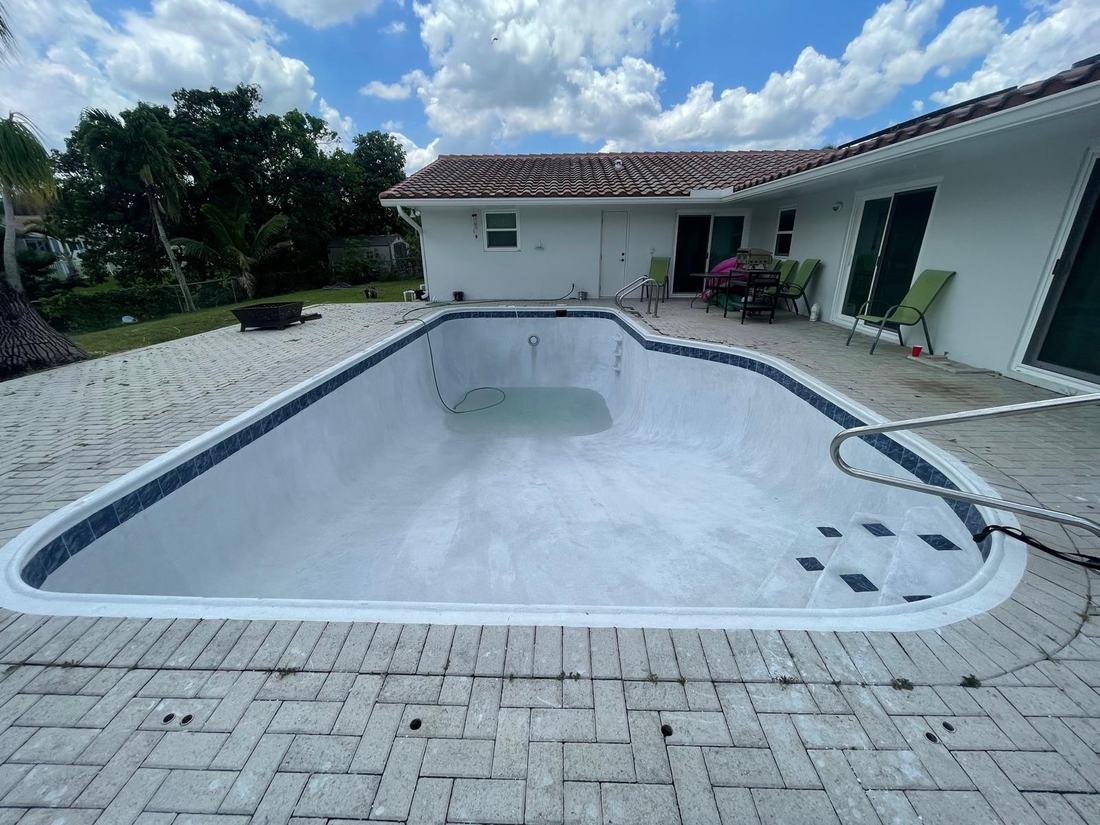Drained pool with faded finish before resurfacing