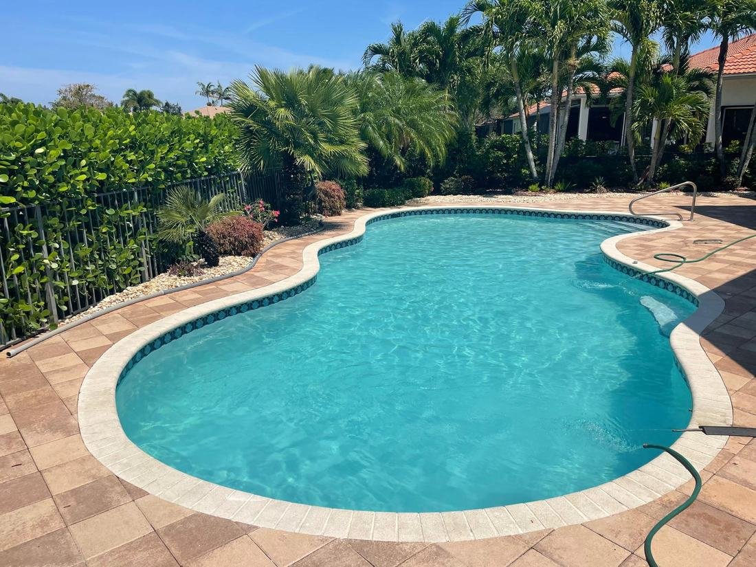 Same freeform pool filled with clear turquoise water